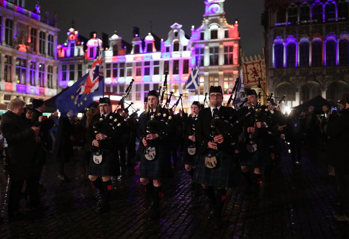 Members of the Celtic Passion Pipe Band playing in Grand Place in Brussels, Belgium, which is lit up in red, white and blue during a celebration and farewell on the eve of the UK leaving the European Union