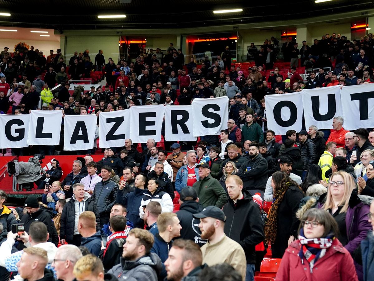 Manchester United fans hold up a 'Glazers Out' sign