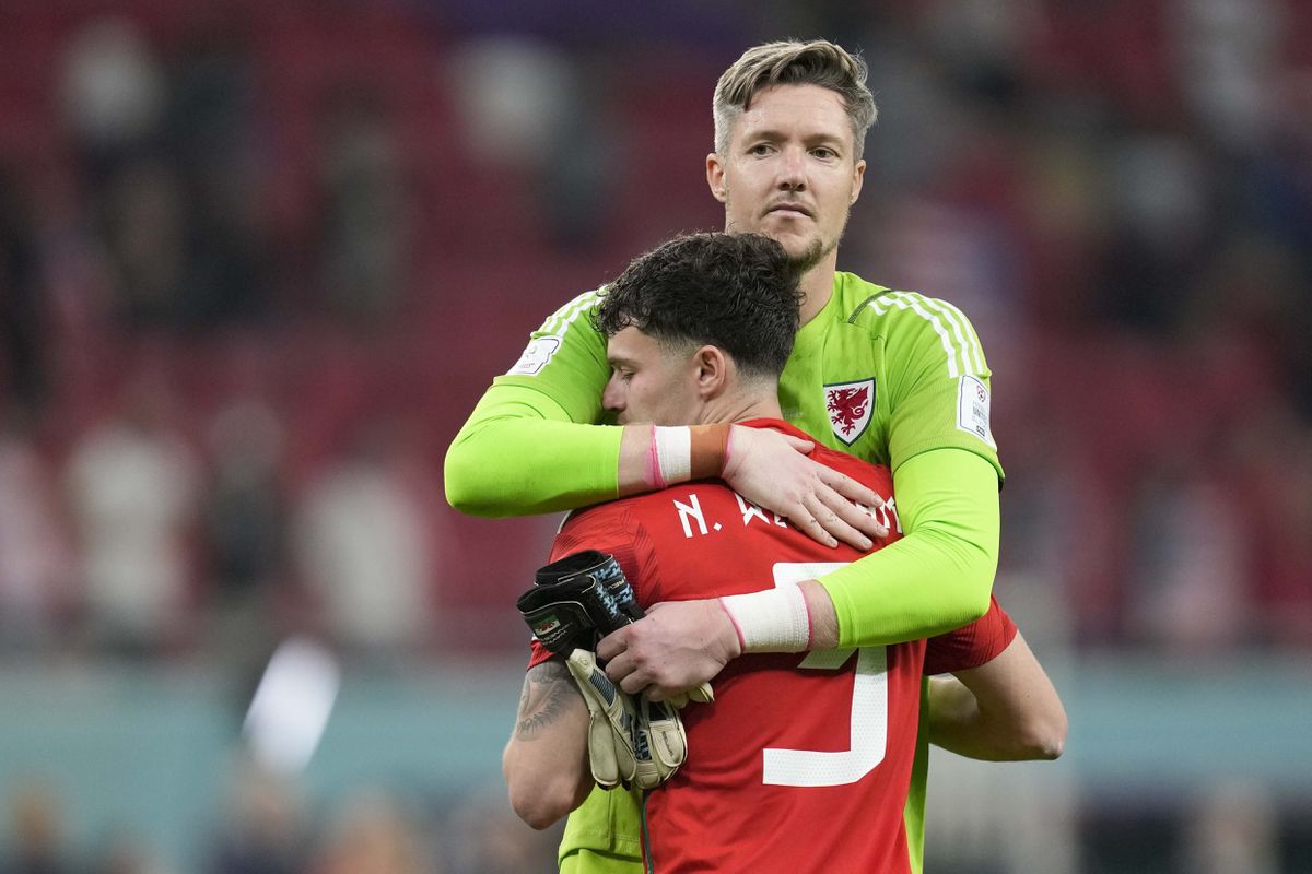 Wales' Neco Williams and Wales' goalkeeper Wayne Hennessey hug during the World Cup, group B soccer match between the United States and Wales, at the Ahmad Bin Ali Stadium in in Doha, Qatar, Tuesday, Nov. 22, 2022. (AP Photo/Darko Vojinovic).