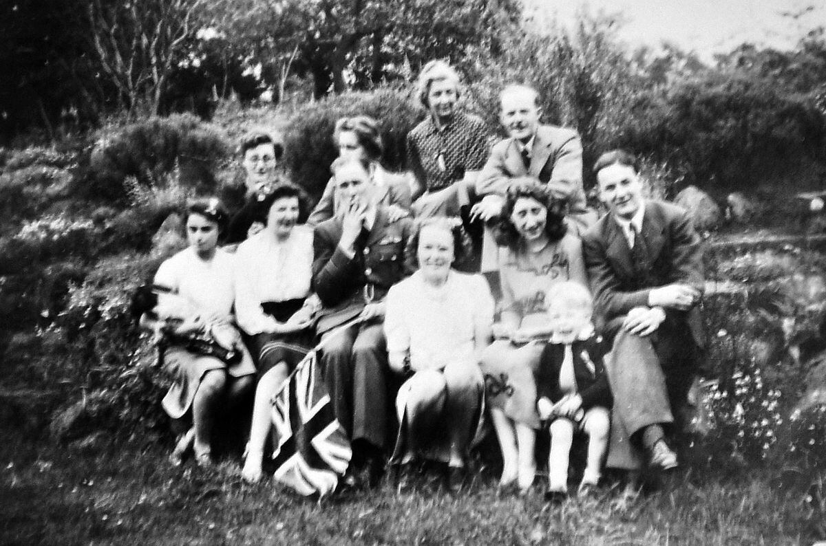 This picture was taken at The Old Hall, Dorrington, on VE Day, and is from a photo album from Mrs Ursula Penny, whose maiden name was Miss Ursula Egerton Hine, born in 1926. She is second from the left, above the flag, wearing a skirt made from blackout material with a bit of added braid. They had two Jewish German refugees staying with them, Marion and Inge Nellhaus, who had fled Germany. Marion is on the left. All the men on the picture were stationed at nearby RAF Condover. 