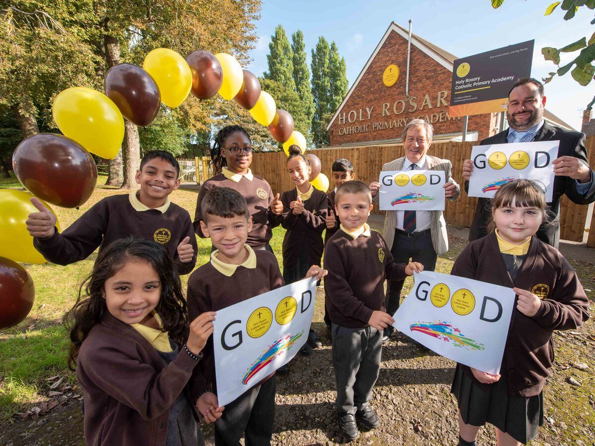 Pupils at Holy Rosary Catholic Primary Academy celebrate being awarding 'Good' Status in their Ofsted Inspection with (centre, back) Councillor Dr Michael Hardacre, the City of Wolverhampton Council's Cabinet Member for Education and Skills and Principal, Adam Jewkes.