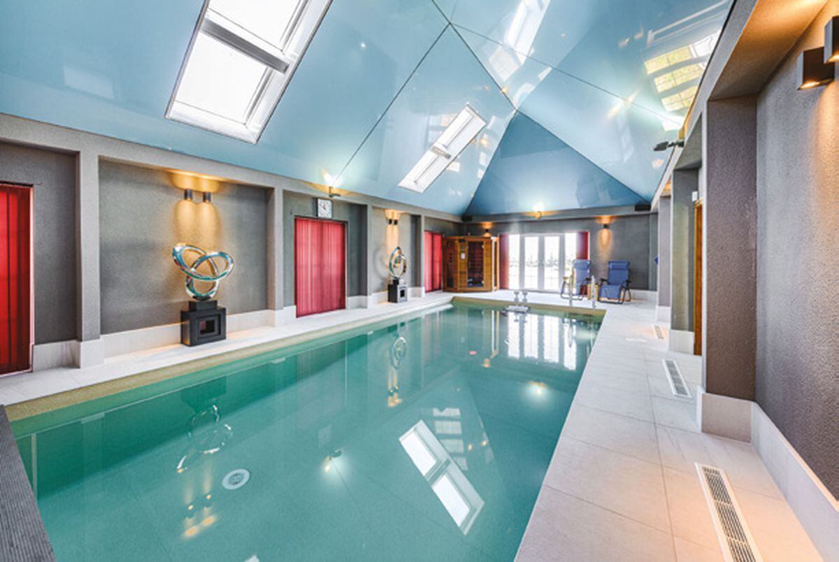 The heated swimming pool has an electric cover and is fitted with an endless pool fast lane