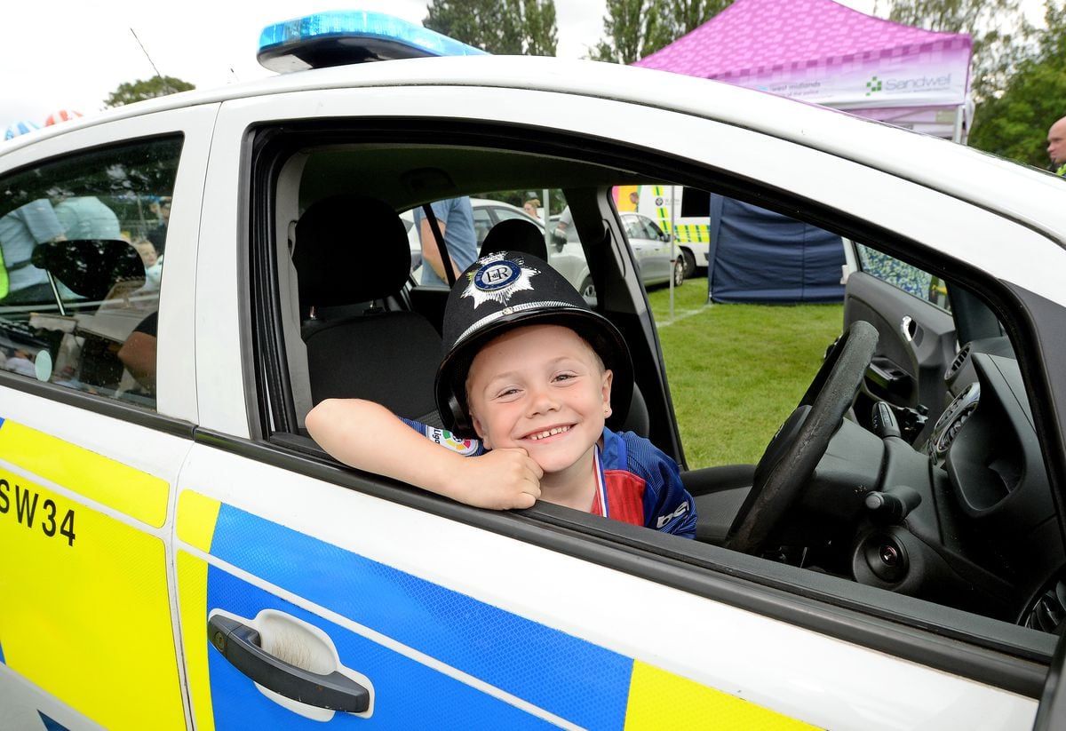 Five-year-old Jenson Stewart enjoys the police car at Wednesbury Carnival