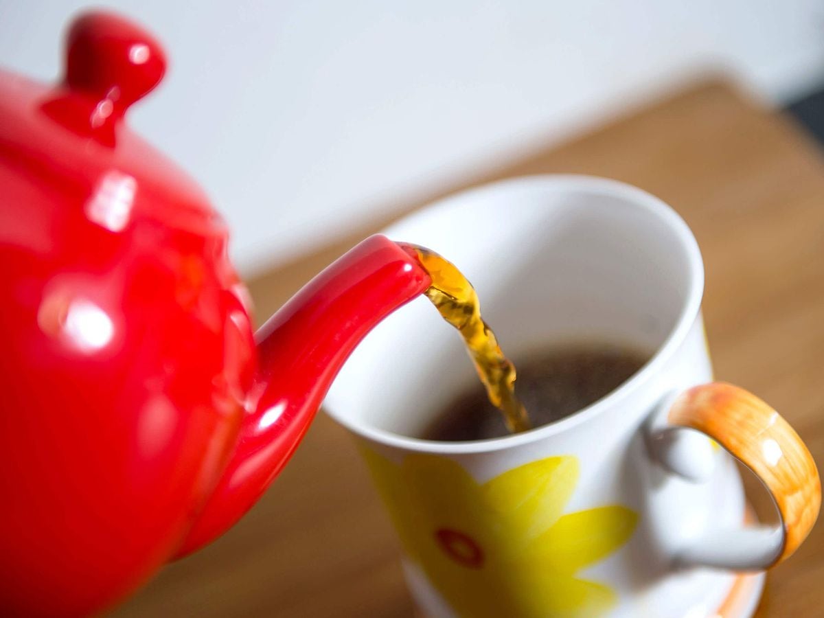 Tea being poured into a mug from a teapot