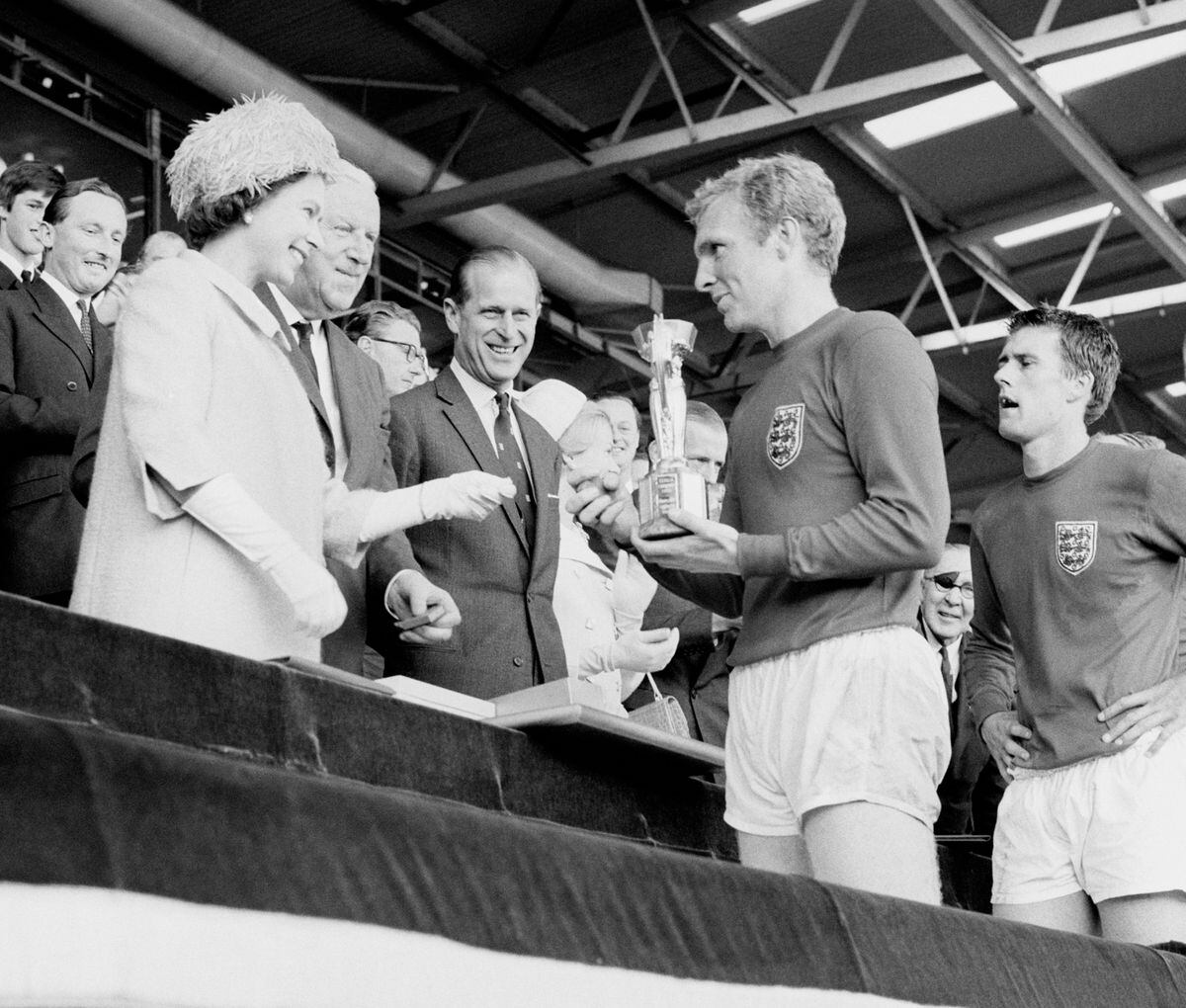 England captain Bobby Moore holds the Jules Rimet Trophy, collected from the Queen 