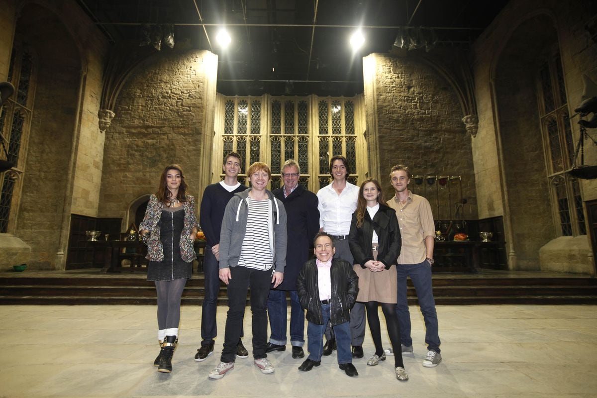 Actors from the Harry Potter movie series, from left, Natalia Tena, Oliver Phelps, Rupert Grint, Mark Williams, Warwick Davis, James Phelps, Bonnie Wright, and Tom Felton, poses for photographs at the 'Great Hall' one of the sets of the movies during a tour in Watford, north of London, Wednesday Oct. 12, 2011. This collection of sheds and soundstages, a former aerodrome near London is where the eight films were shot over almost a decade, and soon they will be home to the official "Making of Harry Potter" studio tour. With more than five months to go until the site's March 31, 2012 opening, tickets go on sale Thursday Oct. 13, 2011. The eight Potter films made here between 2001 and 2010 were a mini-industry, employing both the cream of Britain's acting talent and hundreds of craftspeople and technicians. The tour will show off the skill and craftsmanship that went into the spectacle. (AP Photo/Lefteris Pitarakis) 
