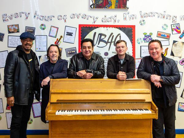 Members of UB40 in front of pupils' work