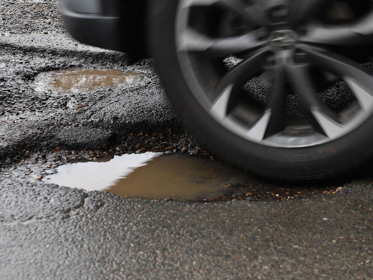 A car passes a pothole in a road near Peterborough, Cambridgeshire