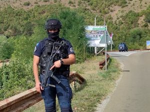 A Kosovo police officer guards the road near the village of Banjska