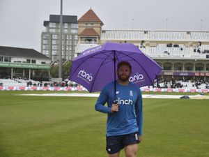 England's Jonny Bairstow holds an umbrella as he walks across the field after rain delayed start of the fifth day of first test cricket match between England and India, at Trent Bridge in Nottingham, England, Sunday, Aug. 8, 2021. (AP Photo/Rui Vieira).