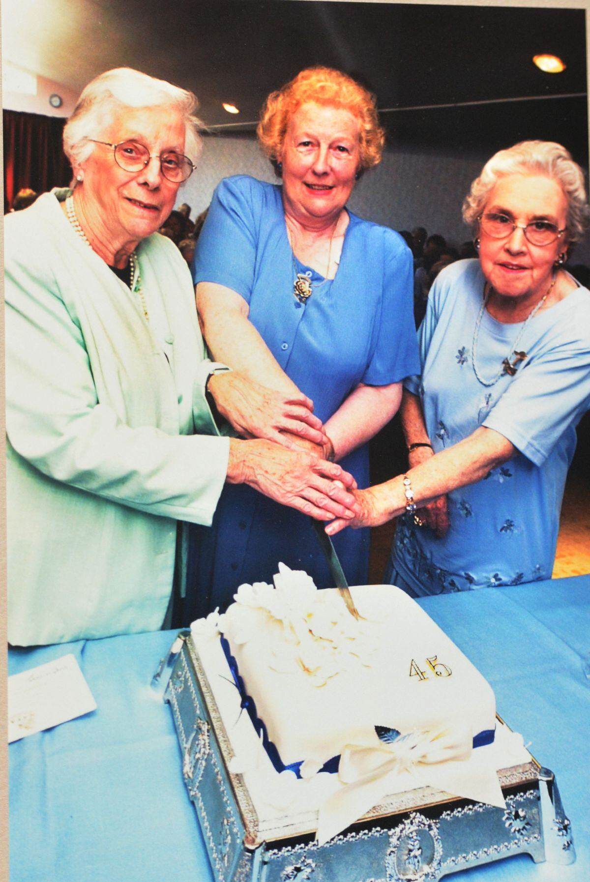 Jean Rudge (founder), Julia Hall (chairman), and Jean Hipwood (president) cut a cake on the 45th Sapphire anniversary of the club in 2000