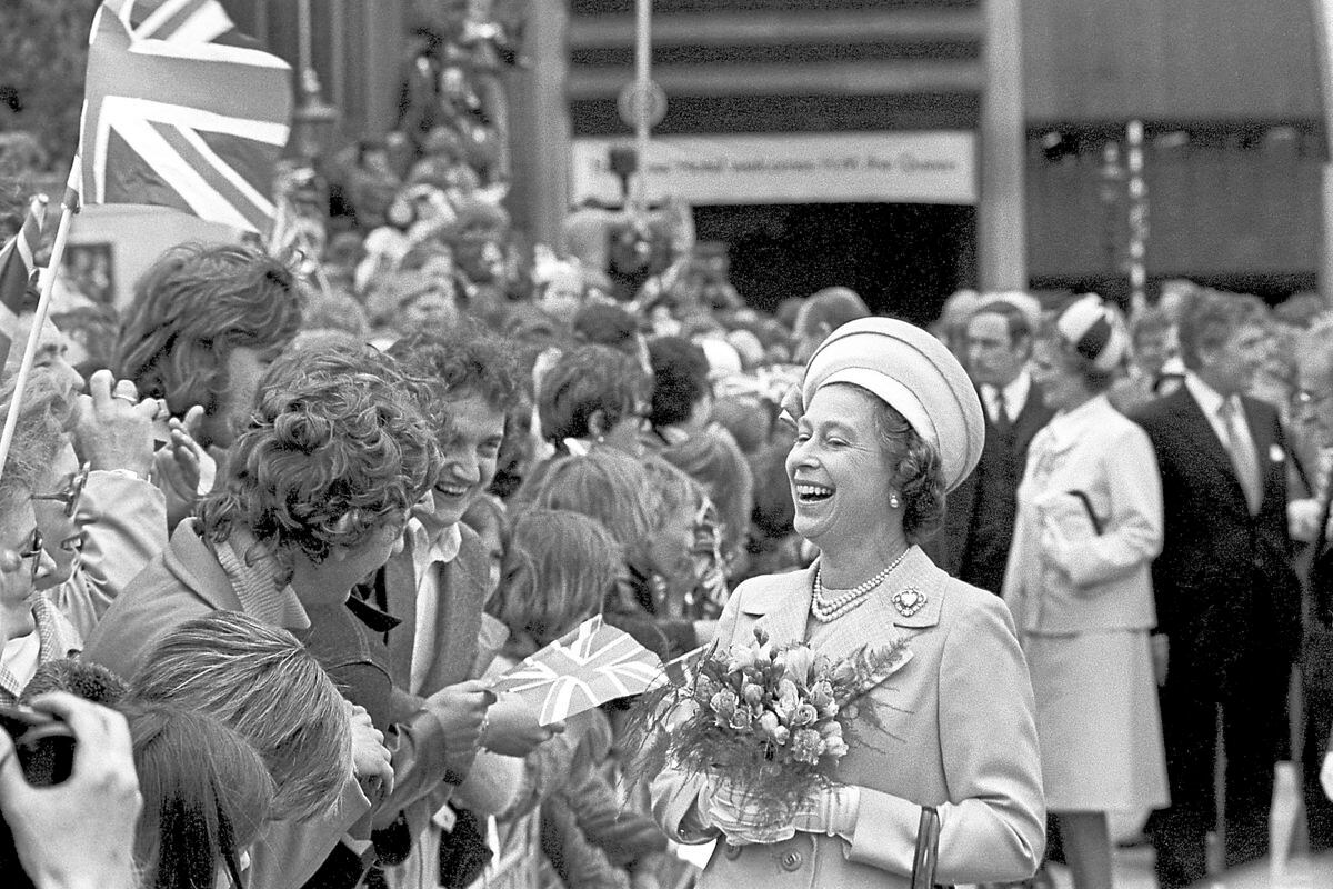Two young men have the Queen rocking with laughter at St Katherine’s Dock, London, where she met the people a Silver Jubilee stop in 1977
