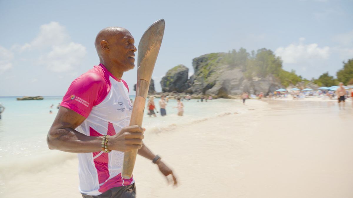 Baton-bearer carrying the baton on the beach in Bermuda