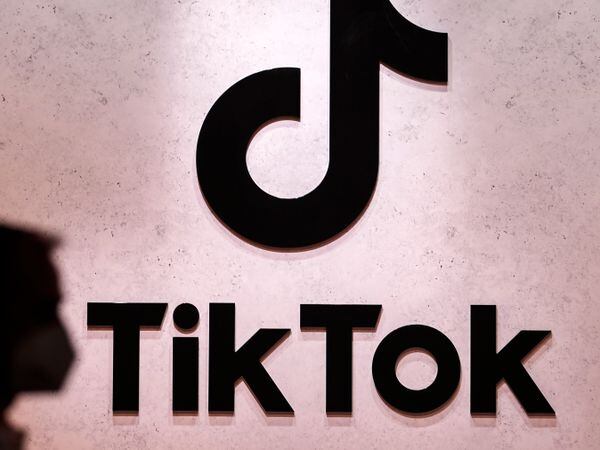 A person passes a TikTok logo