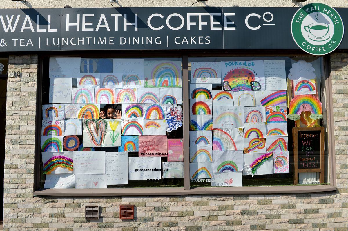 Children have designed rainbow pictures to go in the window of The Wall Heath Coffee Co, Kingswinford. Pictured peeping out from the rainbows is seven-year-old Theo Psaras