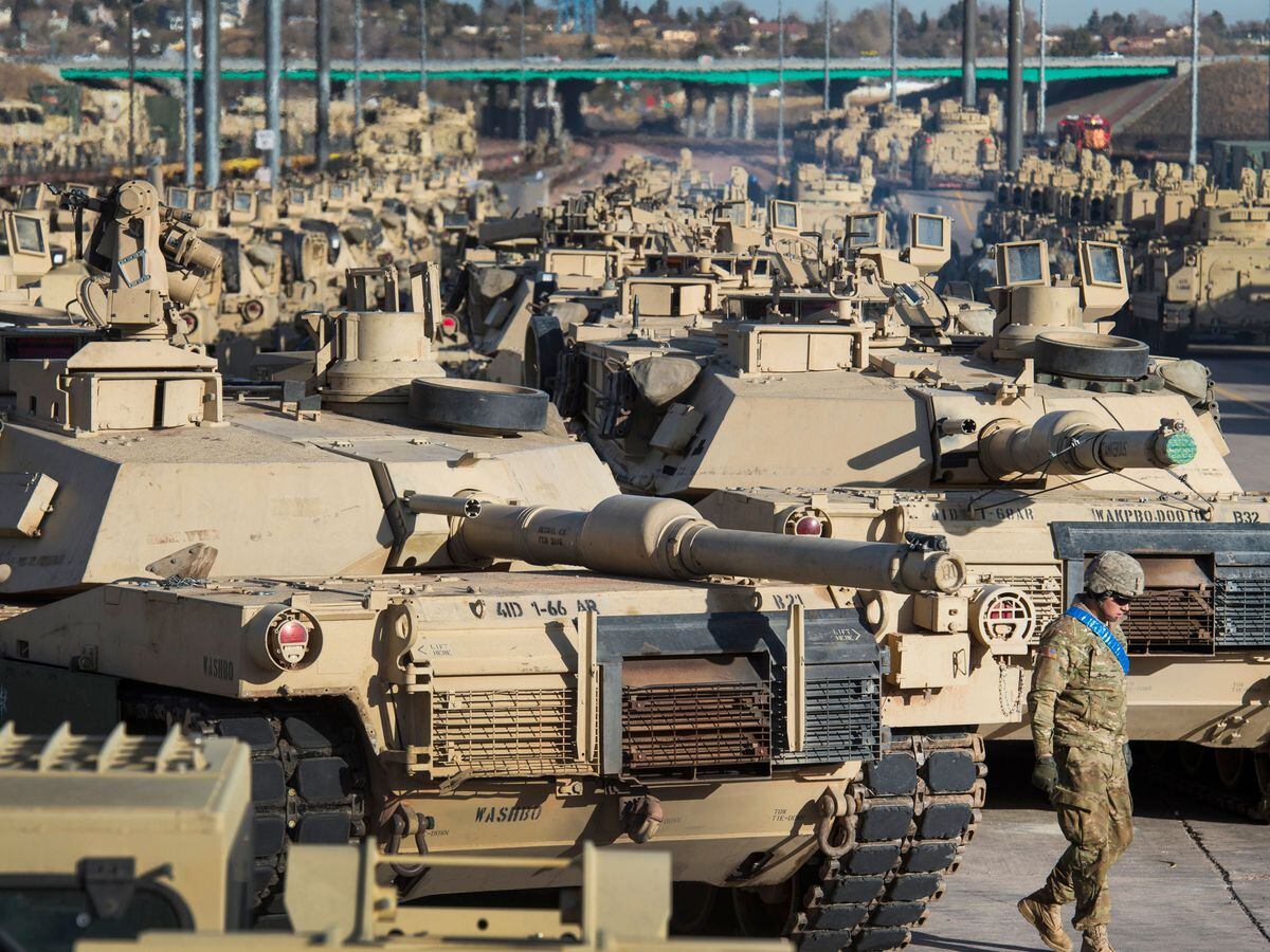 A soldier walks past a line of M1 Abrams tanks at Fort Carson in Colorado Springs, Colorado
