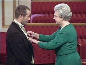STEVE BULL IS PRESENTED WITH THE MBE BY THE QUEEN