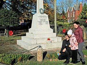 The Petrunia family laying a cross at the war memorial in Enville: Dima, 16, Sasha, eight and mother Kateryna