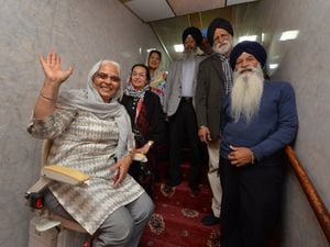 Trying the newly installed stairlift, Iqbal Kaur, with (left-right) Ravinder Gill, councillor Jasbinder Dehar, and committee members, at Guru Nanak Sikh Gurdwara in Wolverhampton.