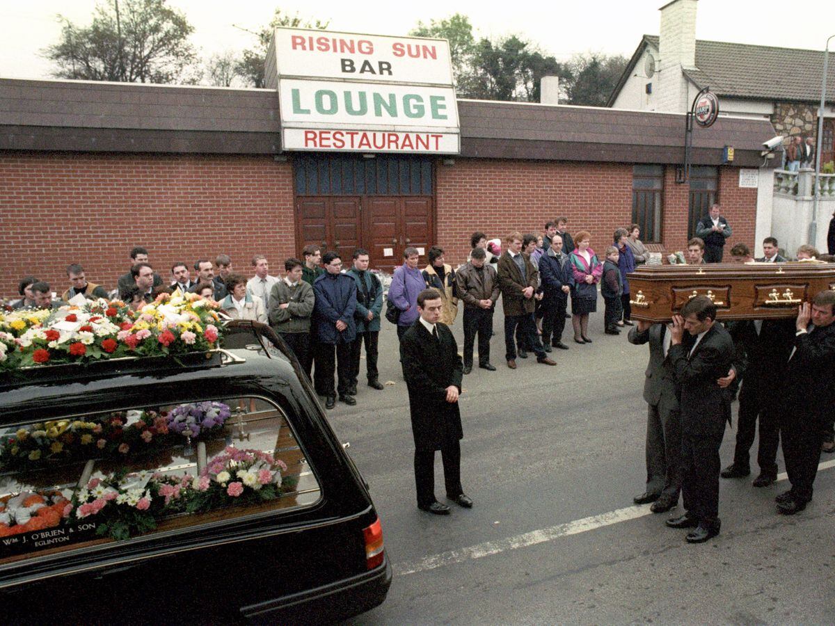 The coffin of Steven Mullan is led past the Rising Sun Bar at Greysteel, Londonderry (PA)