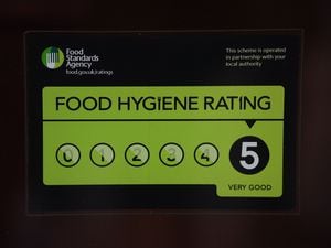 A Food Standards Agency rating sticker on a window of a restaurant.