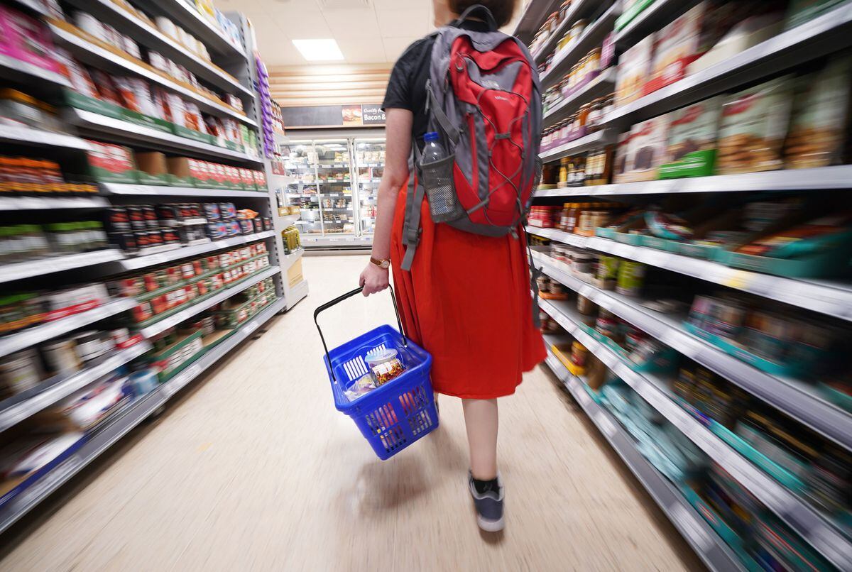 Shopper walking through the aisle of a supermarket. 
