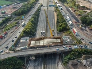 Panels are lowered onto a new bridge being built over the M6 at Junction 10. Photo: Paul Turner