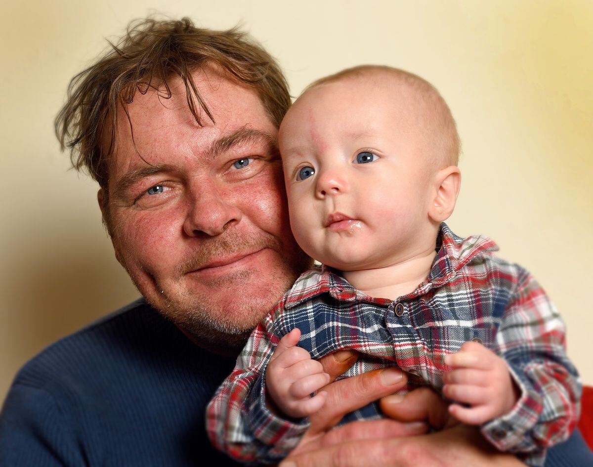 Dave Evans with baby Harry – his lack of biological connection has not stopped him bonding with his son