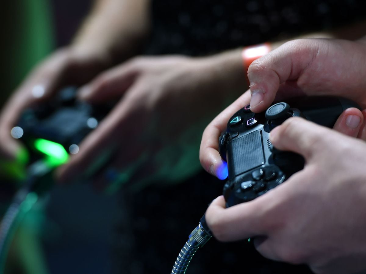 People hold gaming control paddles
