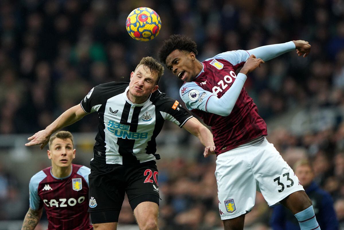Newcastle United's Chris Wood (left) and Aston Villa's Carney Chukwuemeka battle for the ball during the Premier League match at St. James' Park, Newcastle upon Tyne. Picture date: Sunday February 13, 2022..