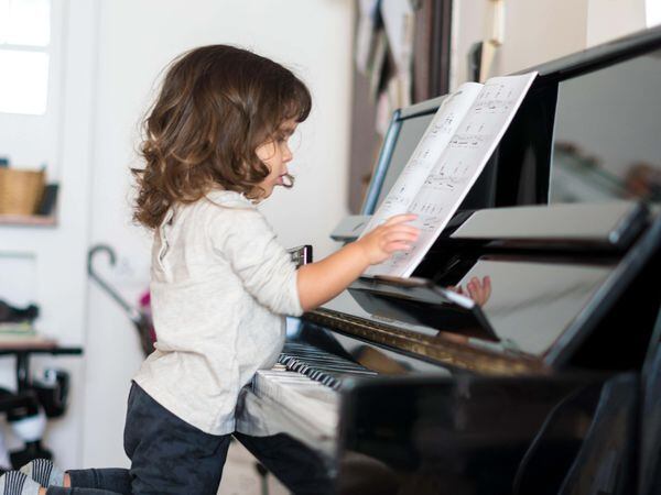 A young girl learning to play the piano