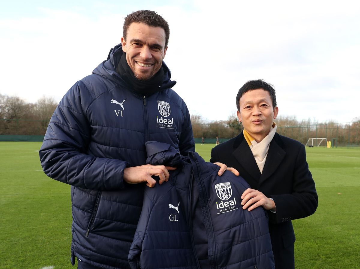 Valerien Ismael gives a bench coat to West Brom owner Guochuan Lai. Photo: Adam Fradgley/West Bromwich Albion FC via Getty Images