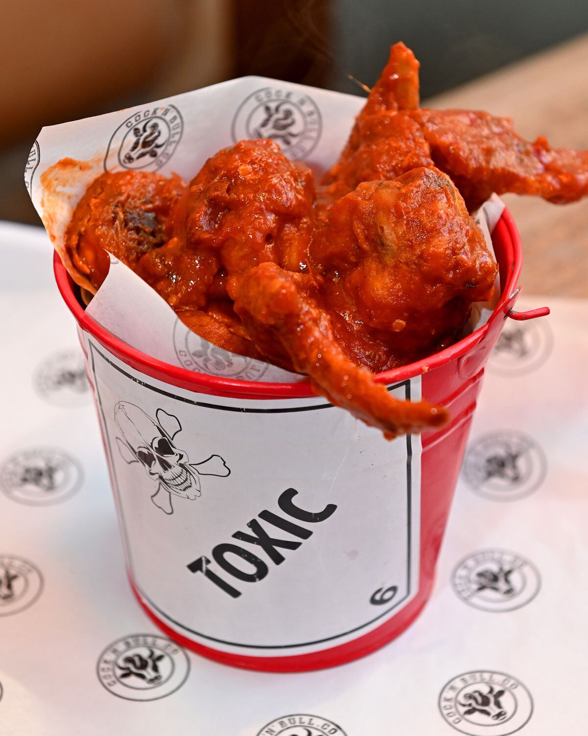 The challenge involves eat six hot wings covered in hot sauce in six minutes, then six minutes to sit and let it burn