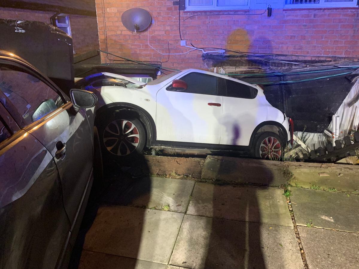 The white Nissan Juke was parked in the road when it was hit and crashed into the house. Photo: @WMFSKingsNorton