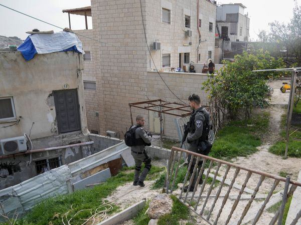 Israeli paramilitary border police stand next to the family home of a Palestinian gunman who killed several people in an attack on Friday outside a synagogue in east Jerusalem