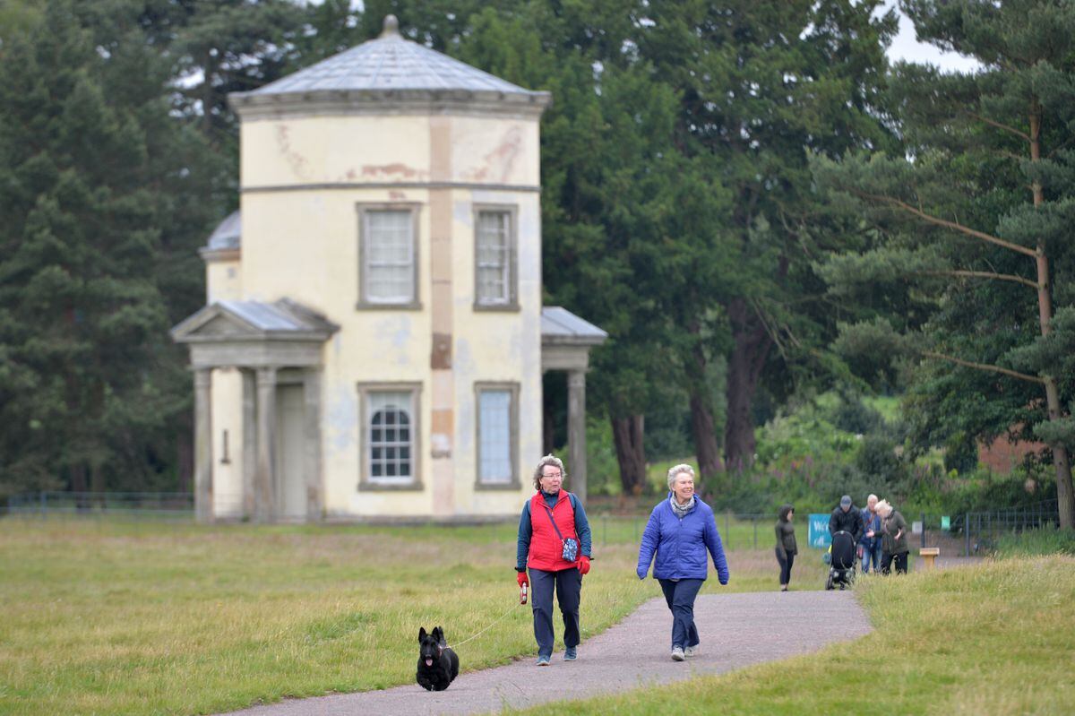 Dog walkers walk past the Tower of the Winds