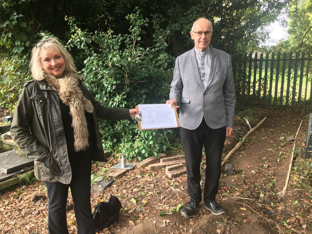 Councillor Jacqui Sweetman accepts the petition from Rev Peter Smith at the rear of the churchyard at St Philip's where the new gate and pathway is planned
