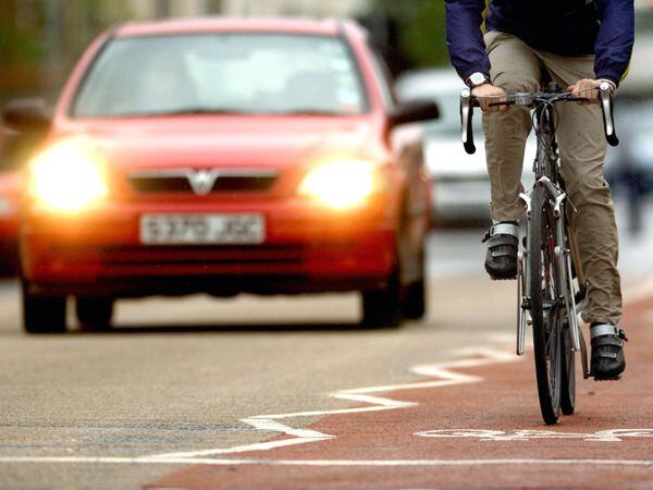 A cyclist using a cycle lane alongside heavy traffic in Cambridge