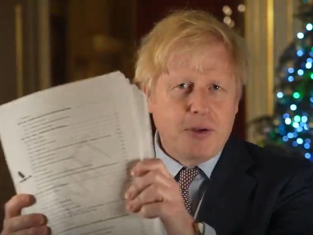Prime Minister Boris Johnson holding up the Brexit deal during his Christmas message recorded in 10 Downing Street (@borisjohnson/PA)