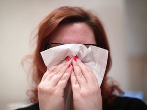 A woman blows her nose