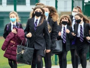 Pupils wearing face masks arrive at school