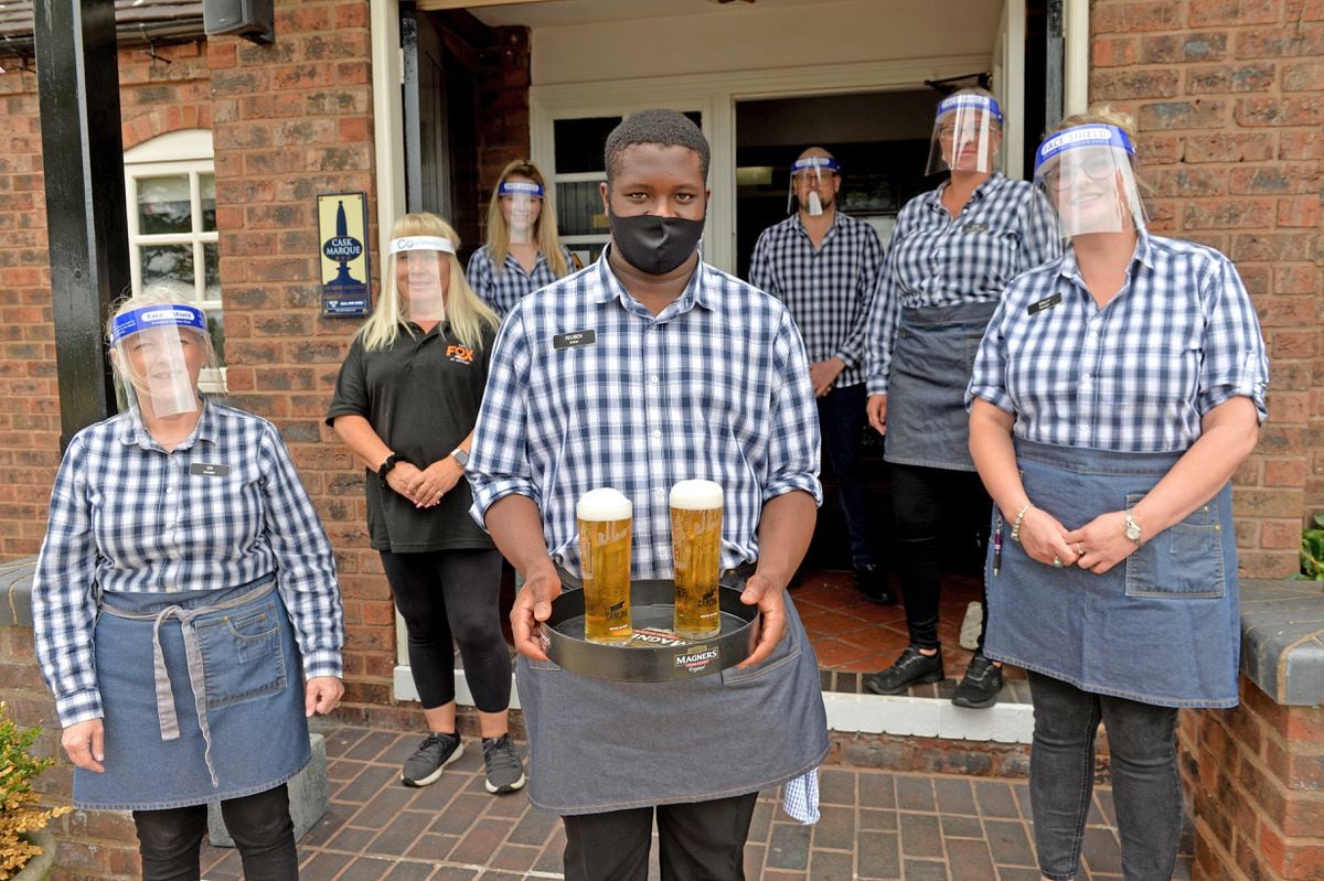 Reuben Thomas (front) and staff wear protective masks and serve drinks at The Fox at Shipley.