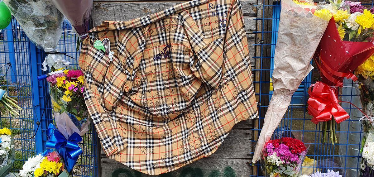 A burberry shirt signed by wellwishers was pinned to the fence