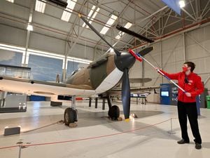 Visitor experience assistant Louis Cawkwell dusts down the Spitfire at RAF Cosford Museum