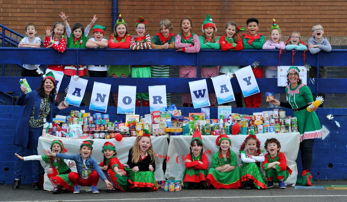 Pictured with the 'elves' are headteacher Lisa Buffery (right) and Lynne Tilby (left) from Black Country Food Bank
