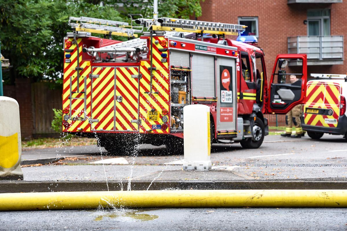Firefighters and Severn Trent workers at the flooded road in Northfield, Birmingham. Photo: SnapperSK