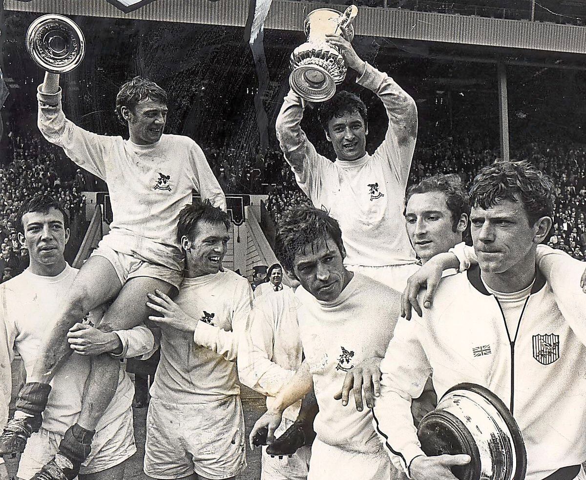 Jeff Astle, third from left, helps hoist Clive Clark, holding the lid of the FA Cup, after Albion’s Wembley win in 1968