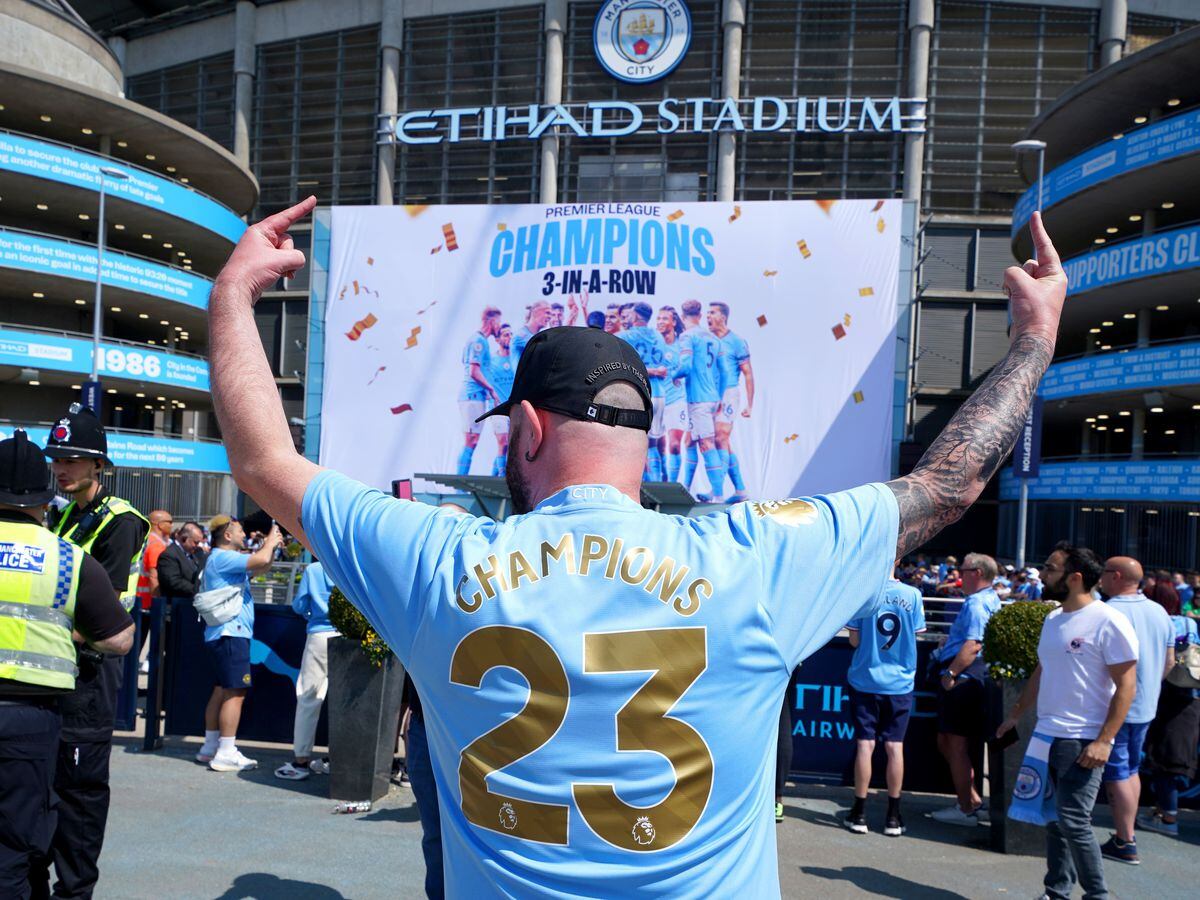 A Manchester City fan poses for a photo