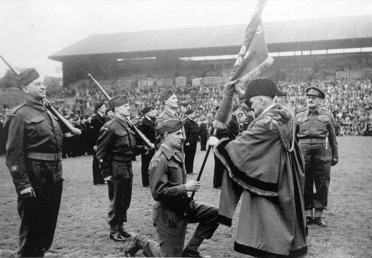 Mayor of Wolverhampton, Councillor T.W. Phillipson, is pictured with members of the Home Guard contingent at a victory event at the Molineux.