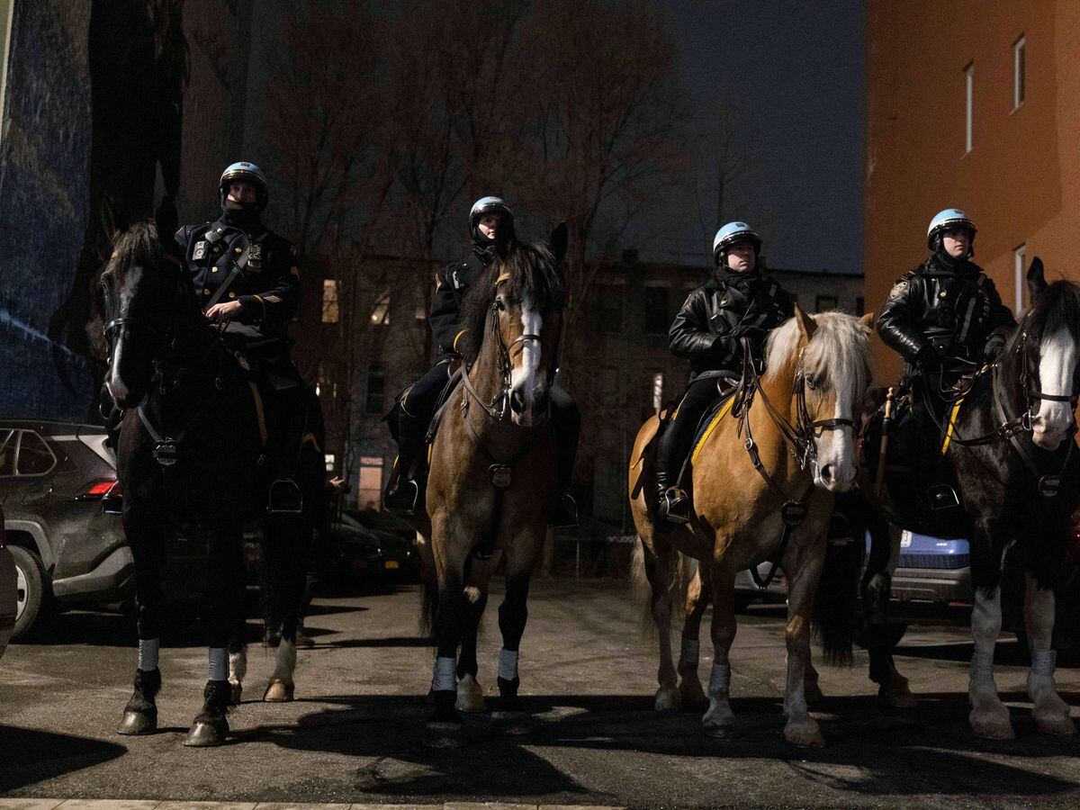Mounted New York City Police Department officers gather for a candlelight vigil outside NYPD Officer Wilbert Mora’s apartment building (Yuki Iwamura/AP)